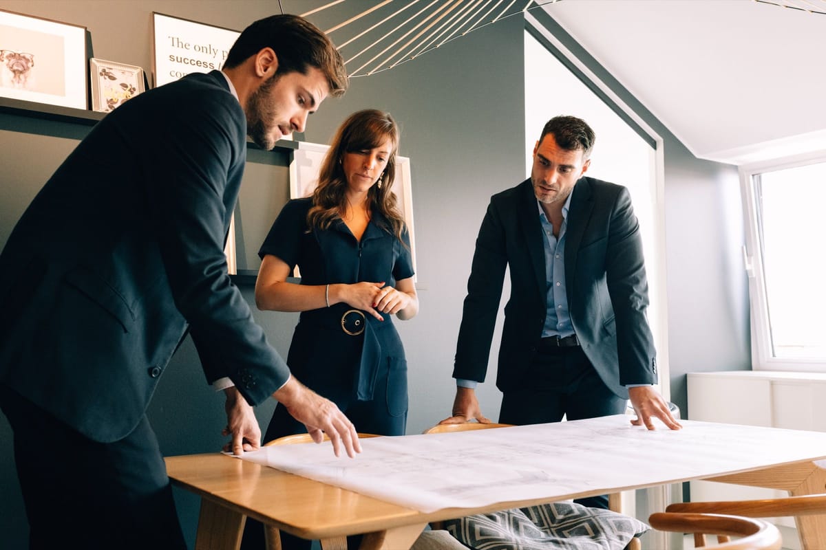 Des conseillers We Invest étudient un dossier et des plans